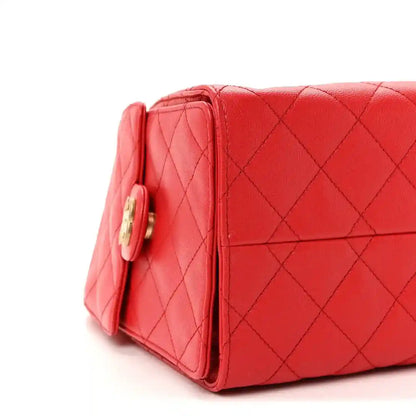 Quilted burgundy leather handbag, side view with turn-lock hardware.