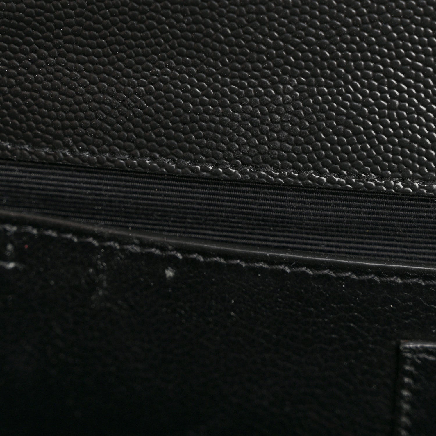 Quilted satchel leather detail with black textured finish and stitched edge