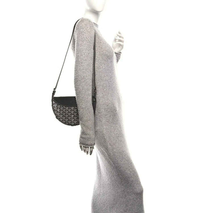 Grey canvas shoulder bag with leather side panel, strap, and metal rings