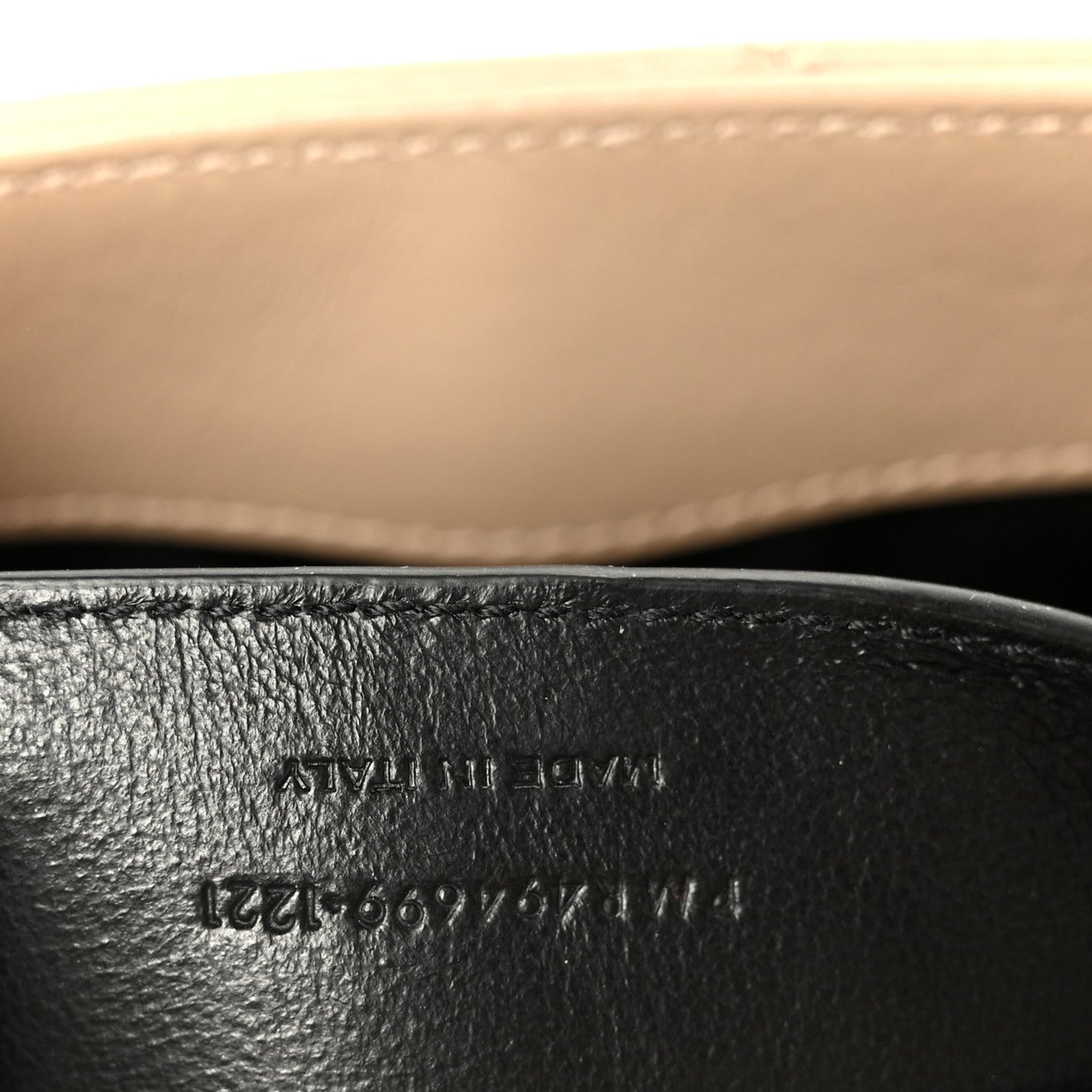 Black leather satchel interior stamp text beneath the zipper edge