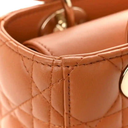Small tote opening with quilted orange lambskin lining and stitched edge trim