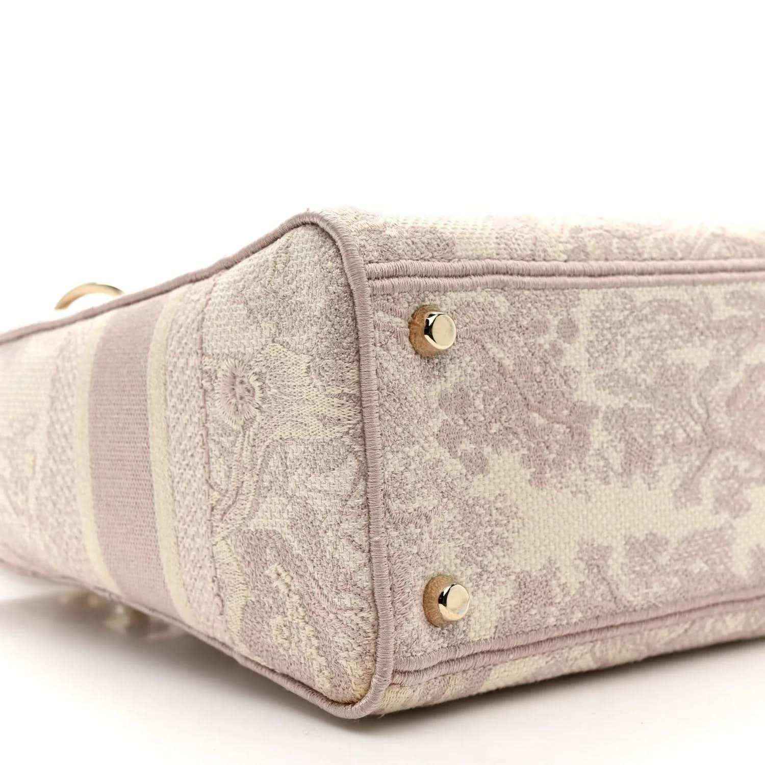 Rose-pink embroidered handbag side with two gold studs and fabric panel detail