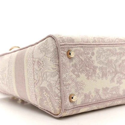Rose-pink embroidered handbag side with two gold studs and fabric panel detail