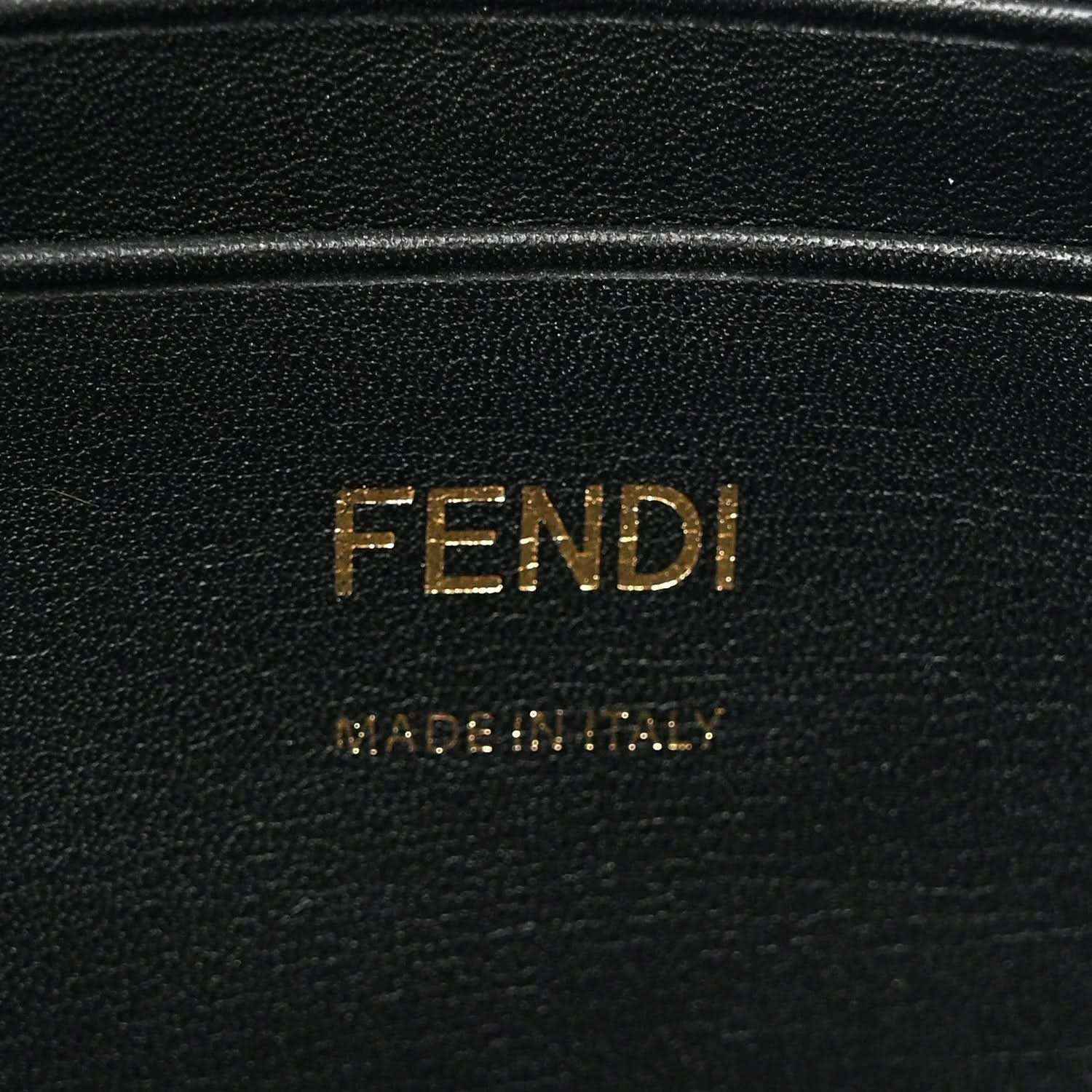 Black leather patch with FENDI lettering, close-up on mini baguette bag.