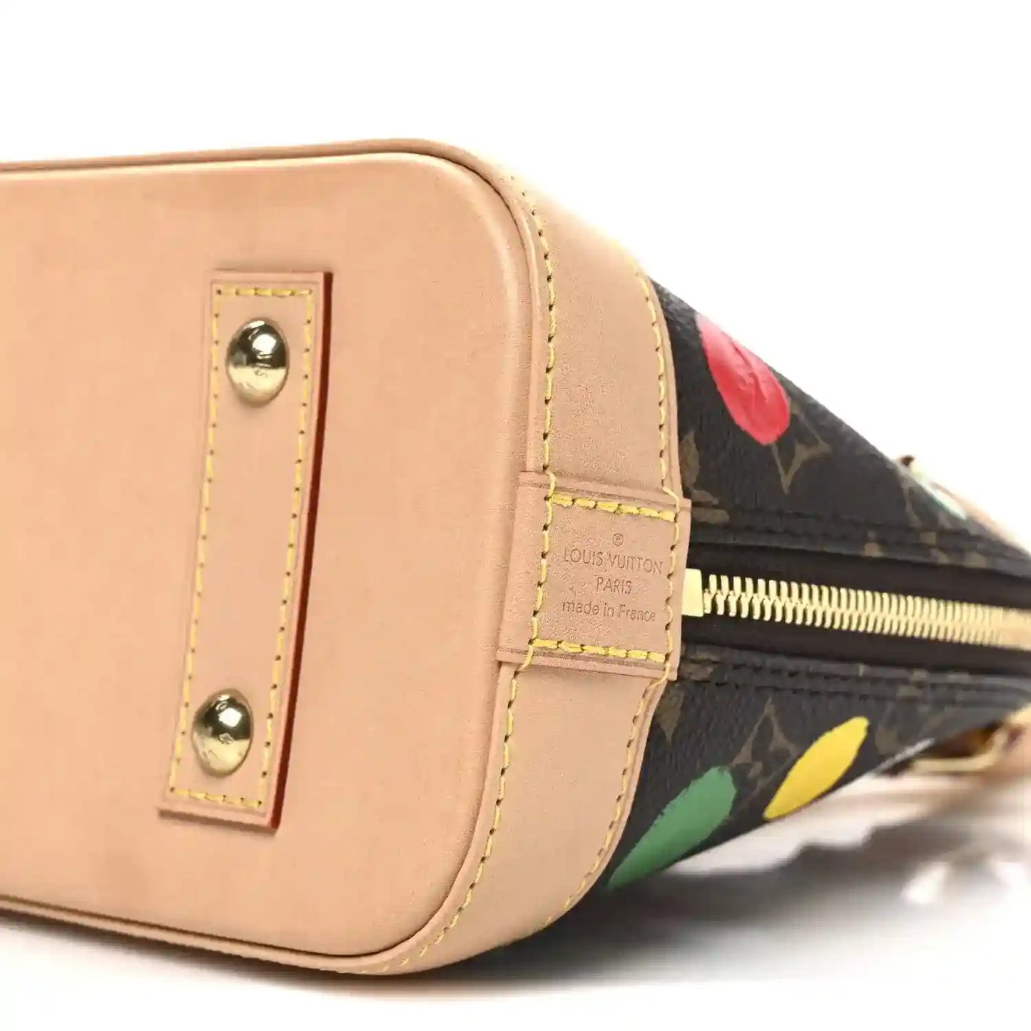 Tan side panel handbag with gold studs and LV label on strap, dot-print trim.