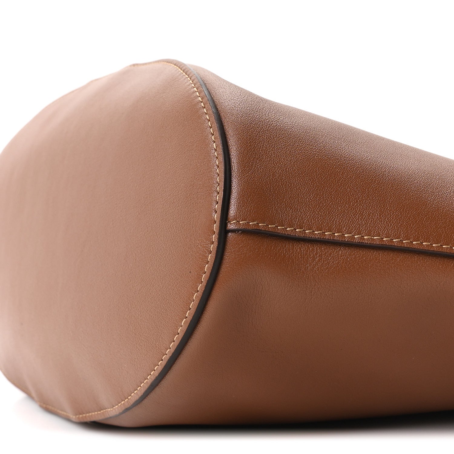 Close-up of tan-brown calfskin drawstring tote end with rounded shape and top stitch
