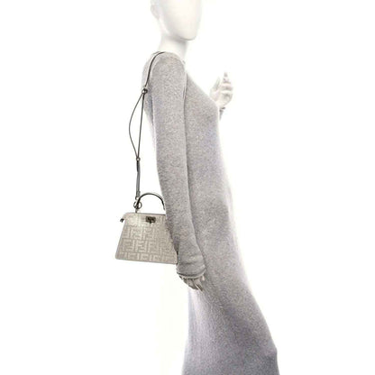 Silver crystal satchel with short handle and adjustable crossbody strap on model