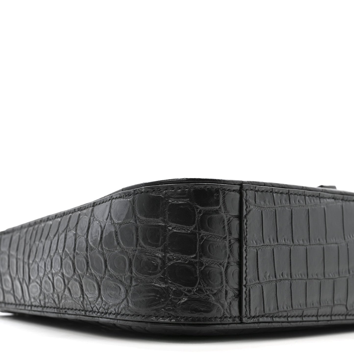 Close-up of bag front panel with crocodile-embossed texture and seams.