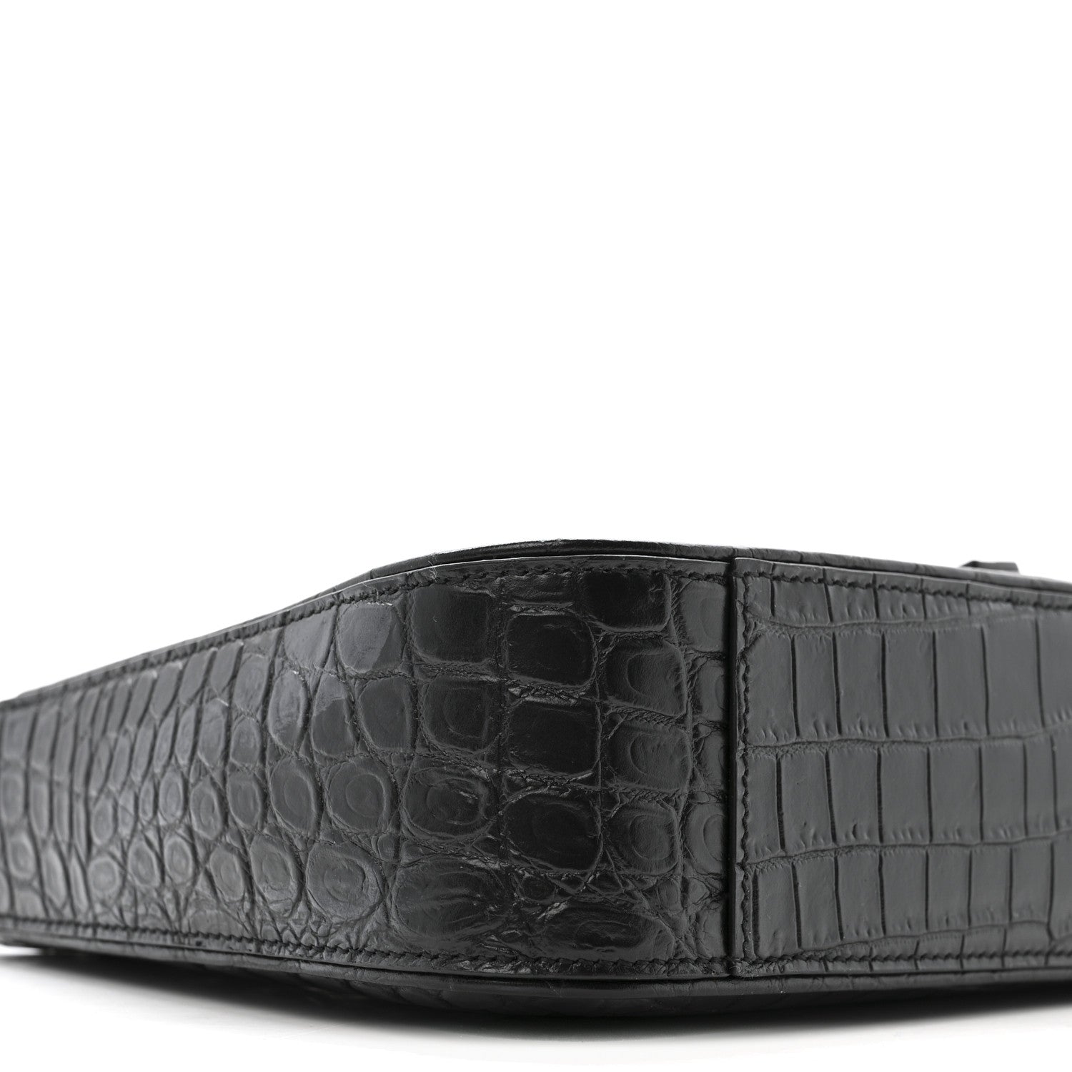 Close-up of bag front panel with crocodile-embossed texture and seams.