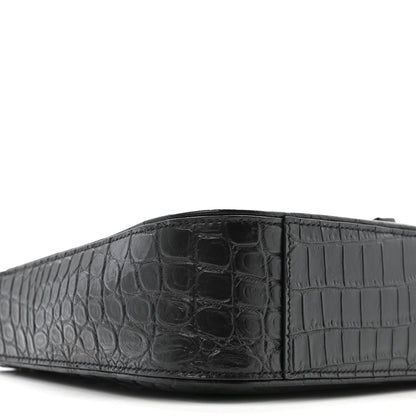 Close-up of bag front panel with crocodile-embossed texture and seams.