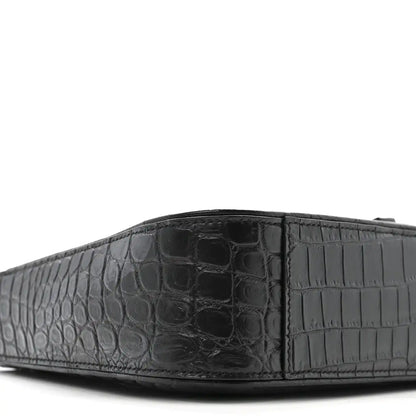 Close-up of bag front panel with crocodile-embossed texture and seams.