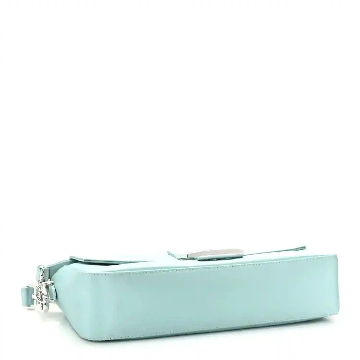 Blue baguette bag with flap top and silver-tone side hardware, profile view