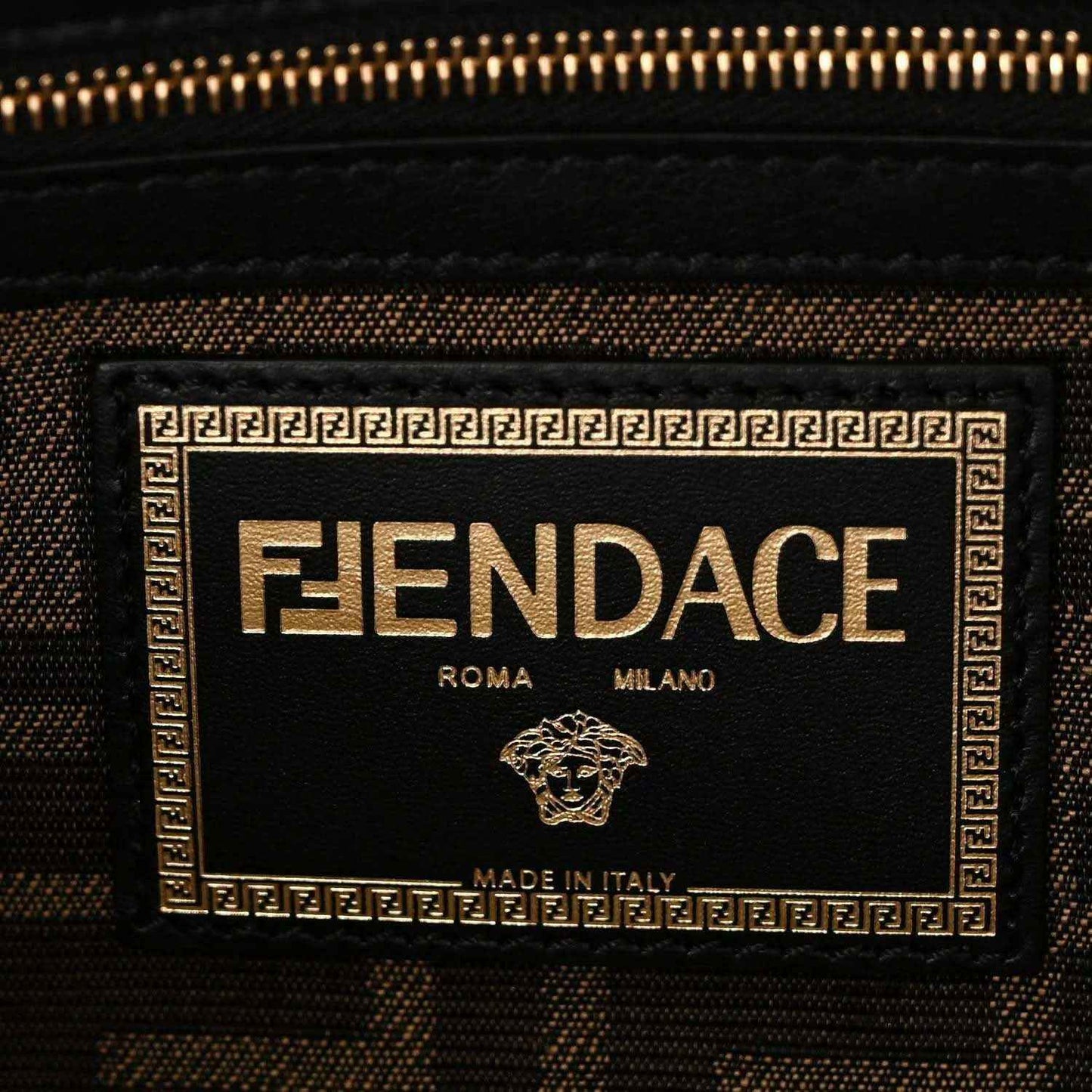 Interior label panel reading FENDACE, with gold zipper and black fabric