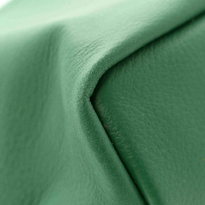 Reversible mini tote bag close-up of green leather-like surface