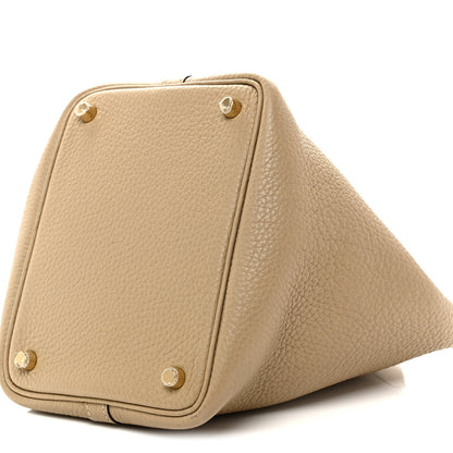 Beige grained calfskin bucket handbag bottom corner view with gold stud hardware.