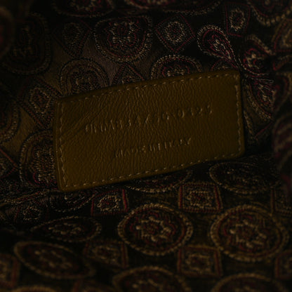 Leather logo tag on jacquard medallion fabric, brown/olive, embossed lettering.