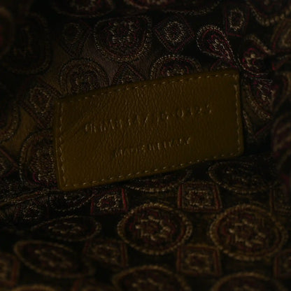 Leather logo tag on jacquard medallion fabric, brown/olive, embossed lettering.