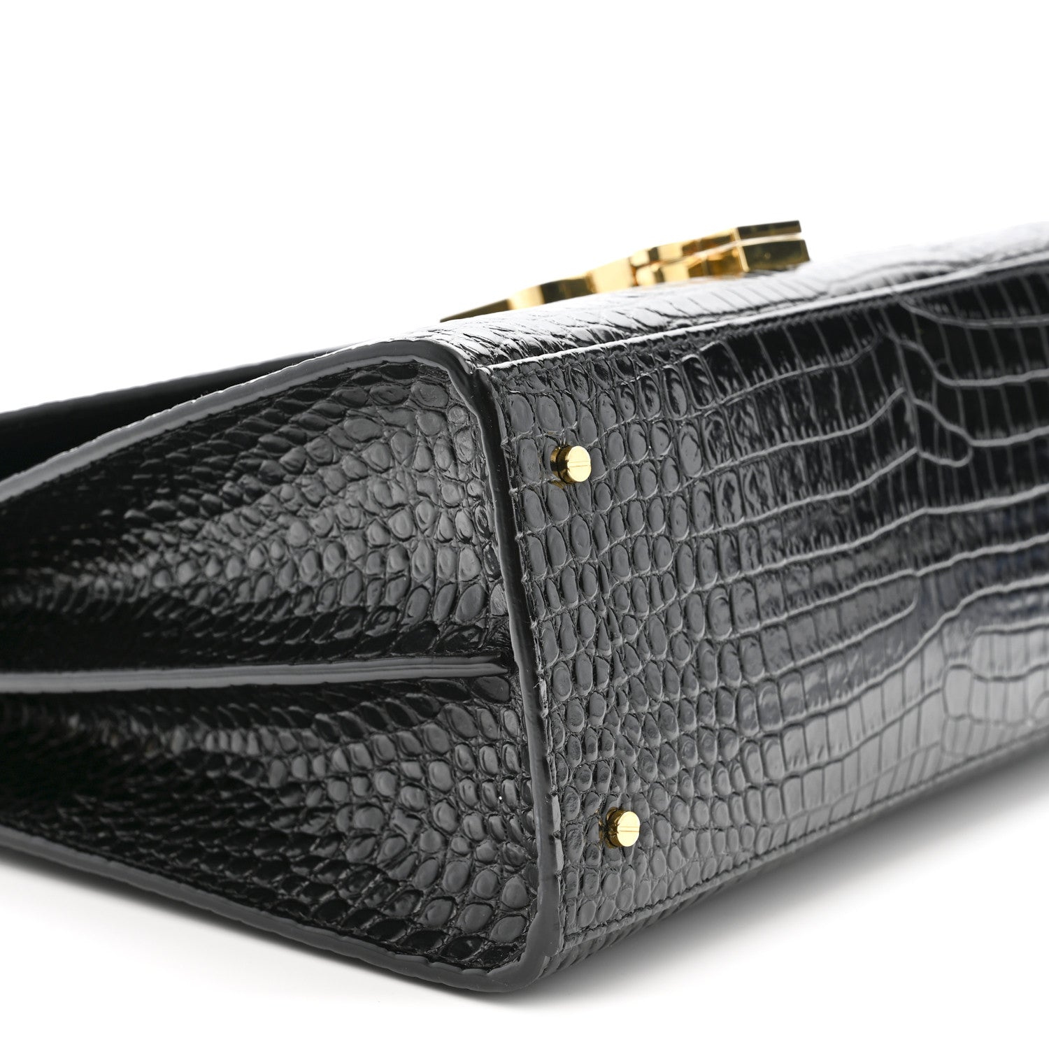 Black crocodile-embossed bag corner with two gold rivets