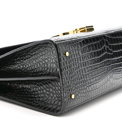 Black crocodile-embossed bag corner with two gold rivets