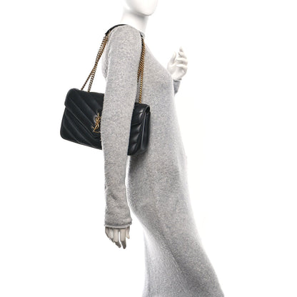Black quilted shoulder bag with gold chain strap and structured side panel