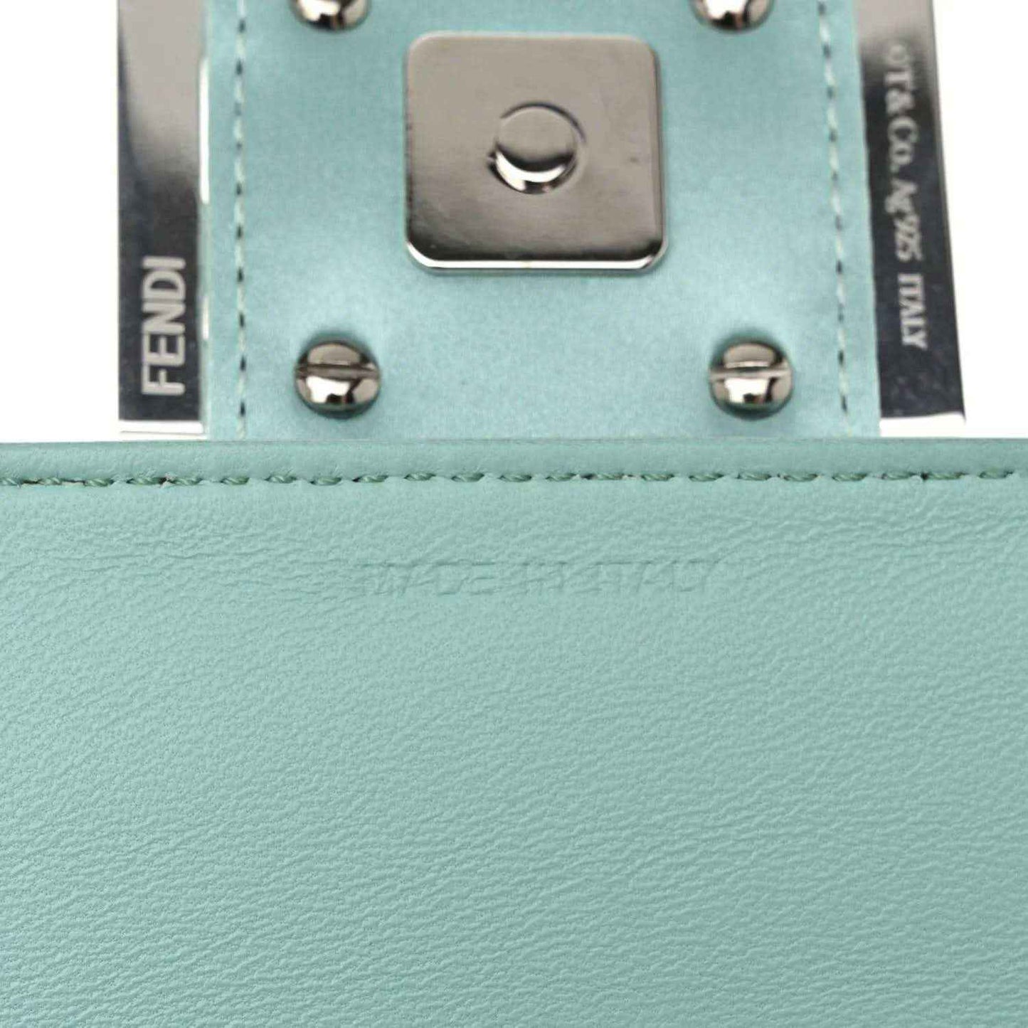 Blue leather baguette bag close-up of snap studs and front hardware