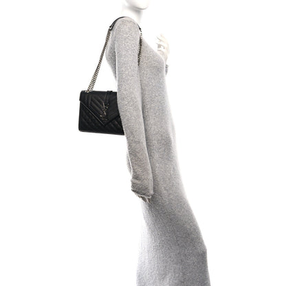Black quilted leather medium satchel with chain strap, shown from the side