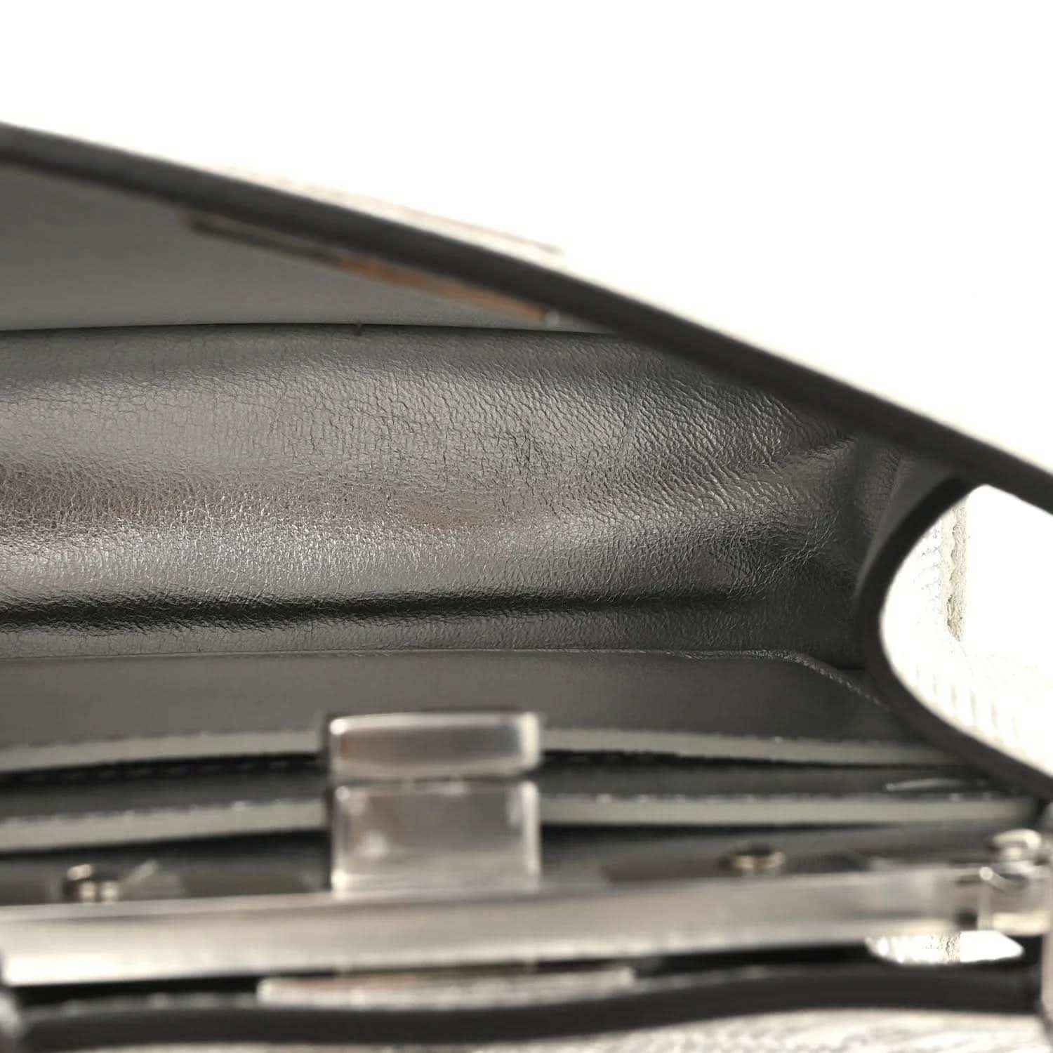 Structured satchel side panel with silver buckle detail and smooth leather trim.