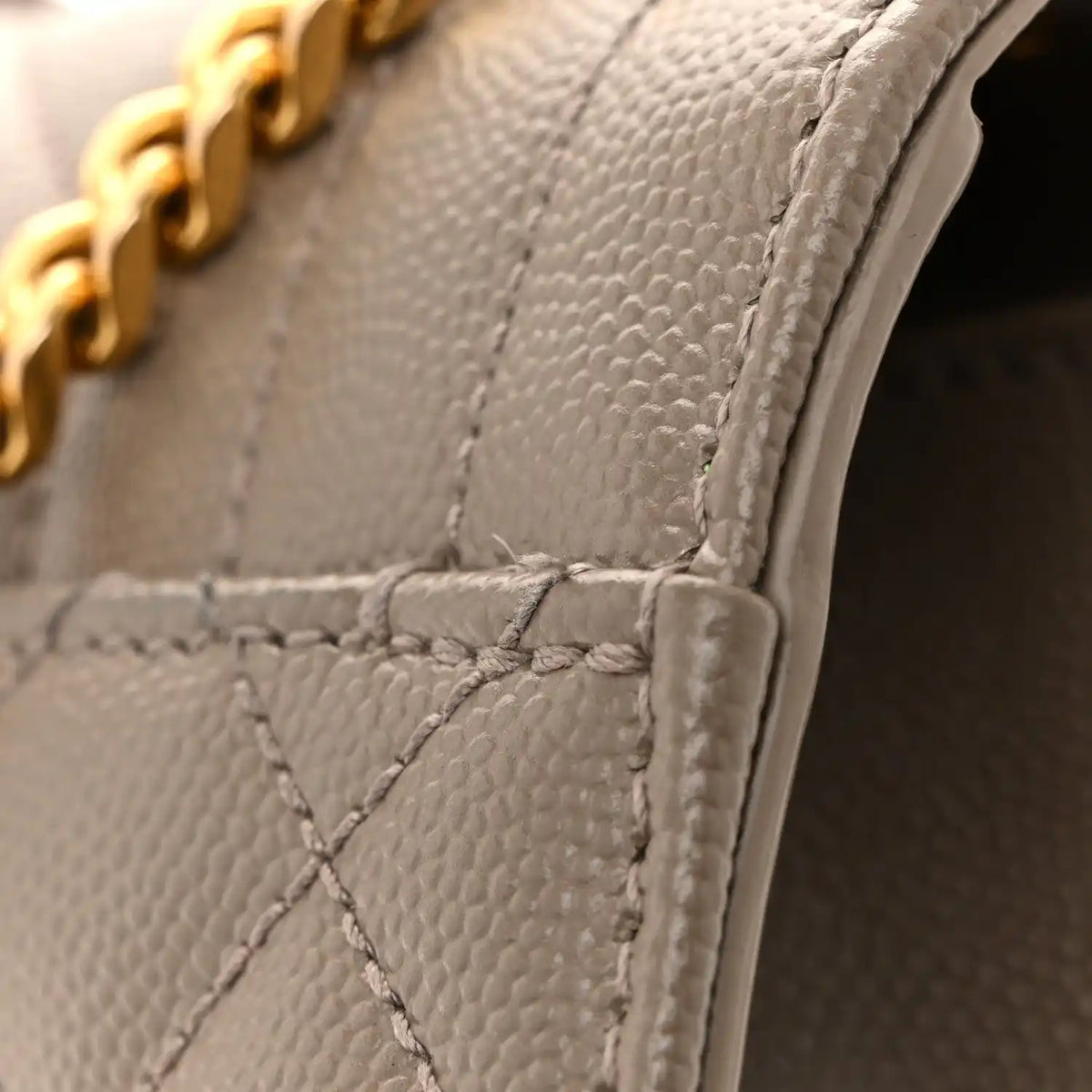 Quilted satchel corner with textured leather and reinforced stitching
