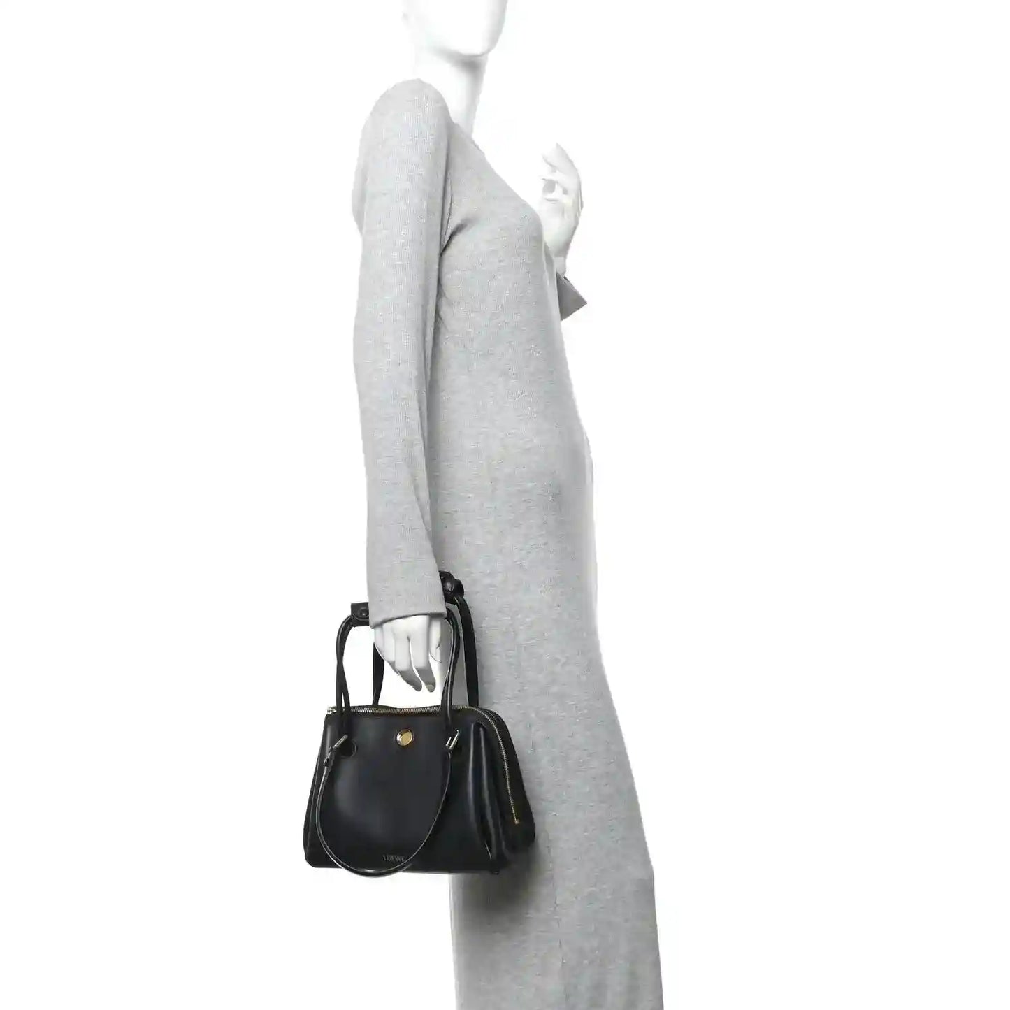 Small Madrid bag in black leather with short strap and gold zip, carried crossbody.