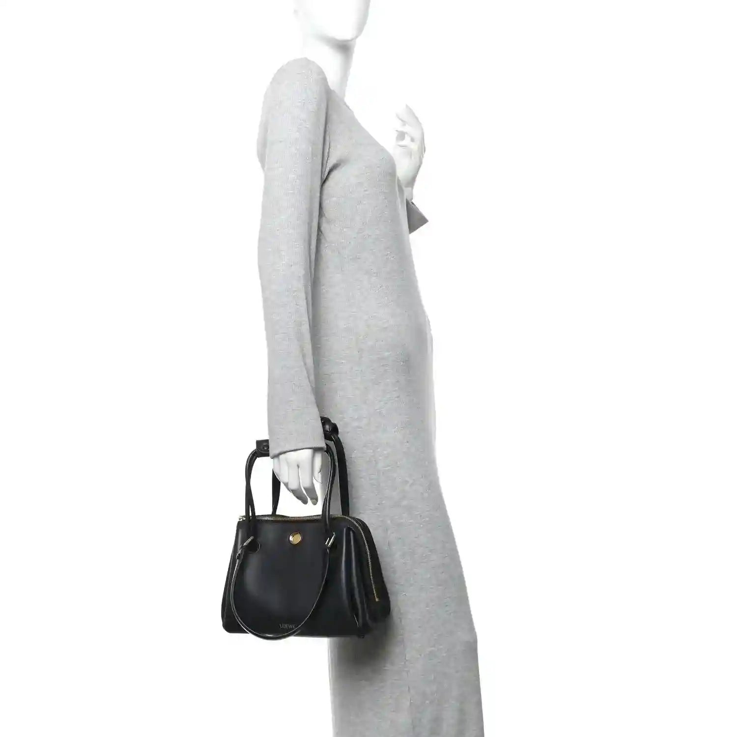 Small Madrid bag in black leather with short strap and gold zip, carried crossbody.
