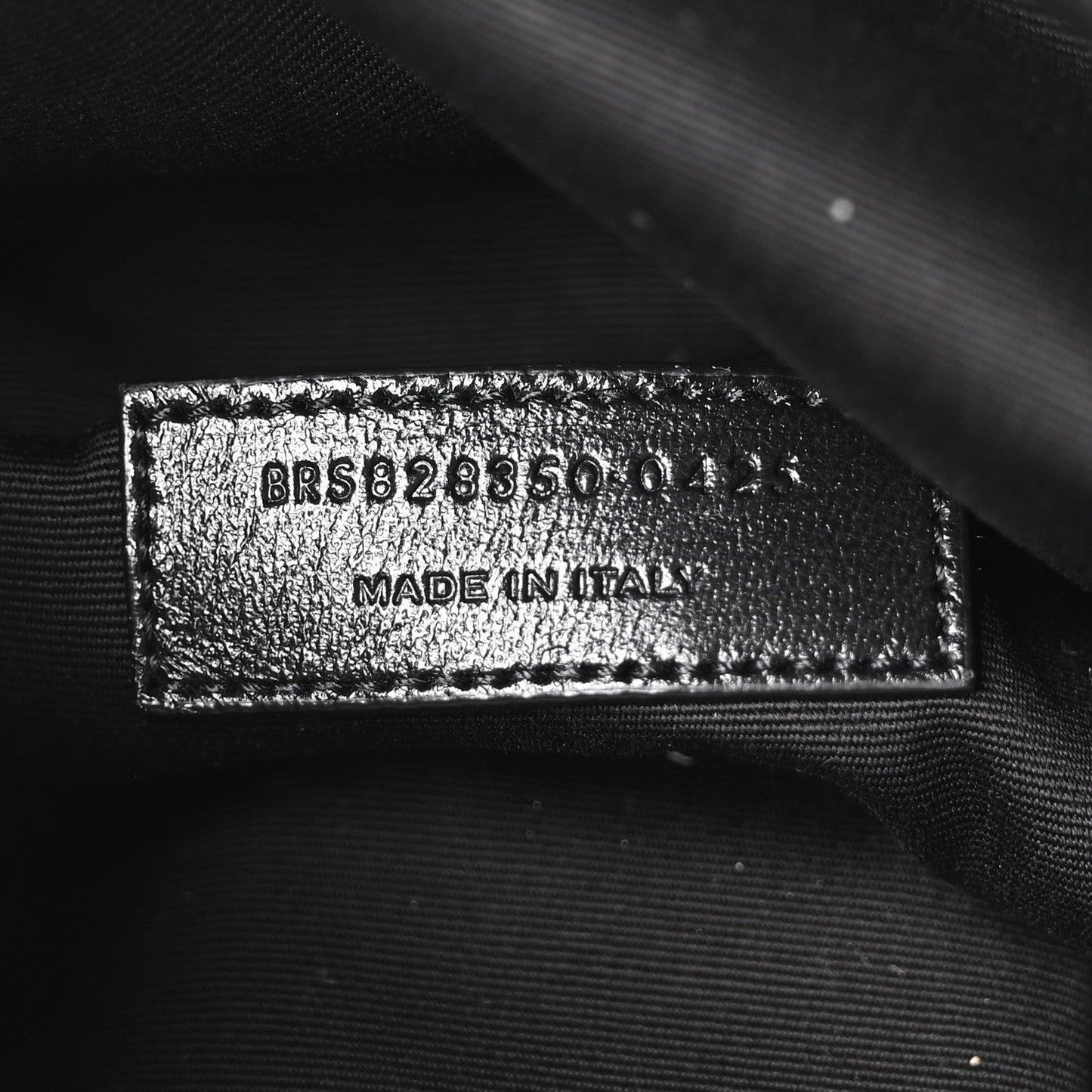 Made in Italy leather brand tag on dark lining with embossed code