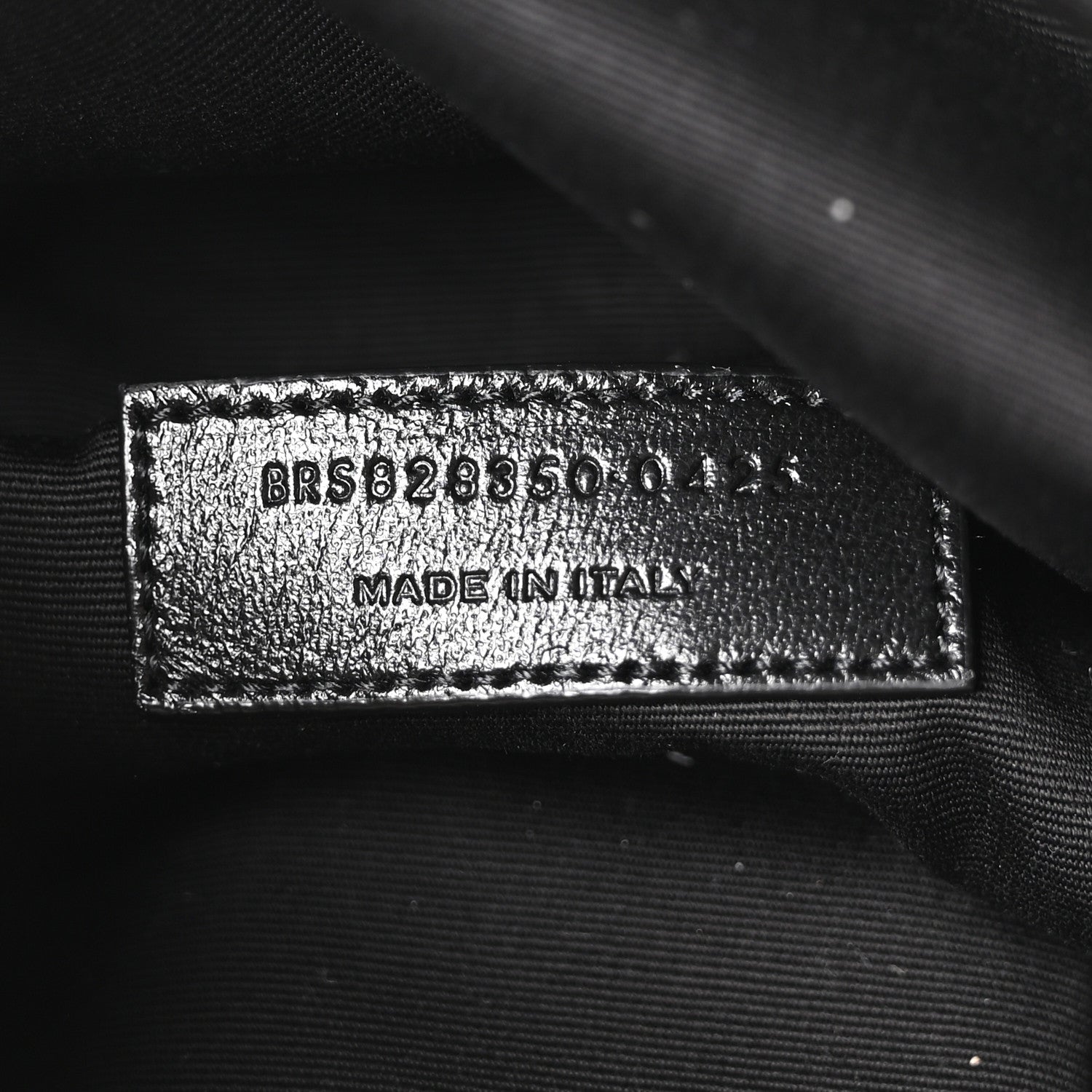 Made in Italy leather brand tag on dark lining with embossed code