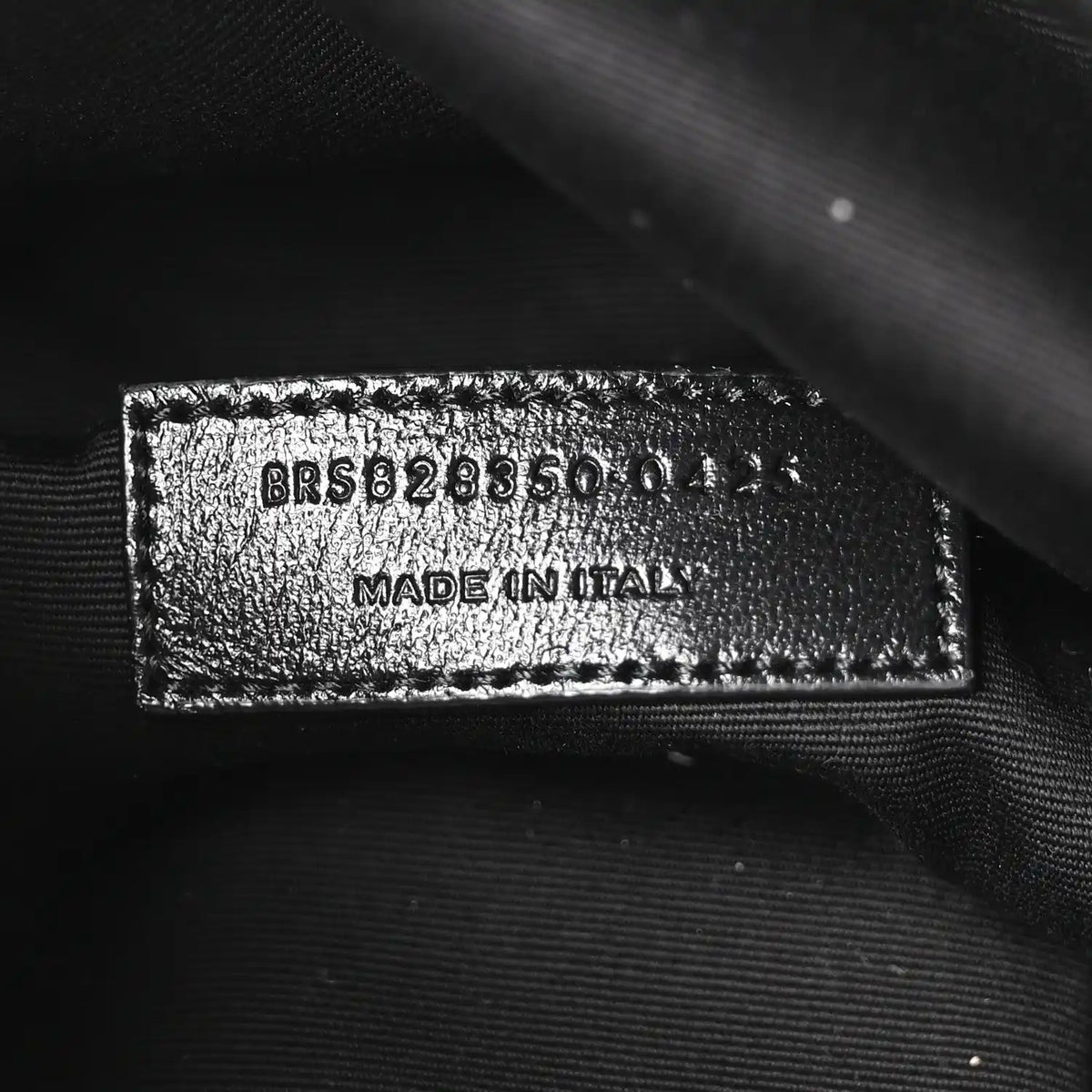Made in Italy leather brand tag on dark lining with embossed code