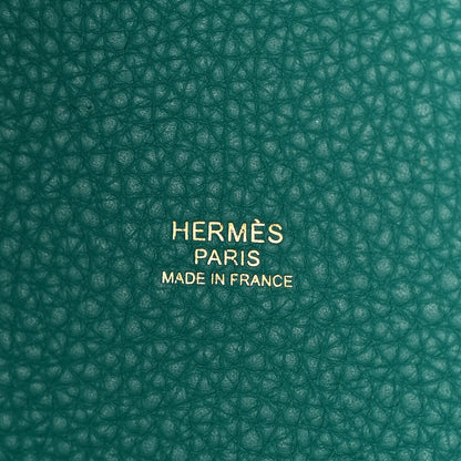 Close-up of green pebbled leather base with centered brand stamp