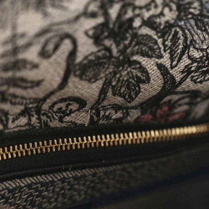 Embroidered denim bag with floral stitching and gold zipper
