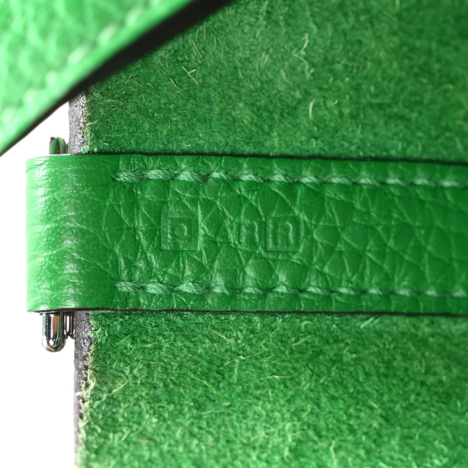 Green leather tote close-up of stitched edge and metal hardware