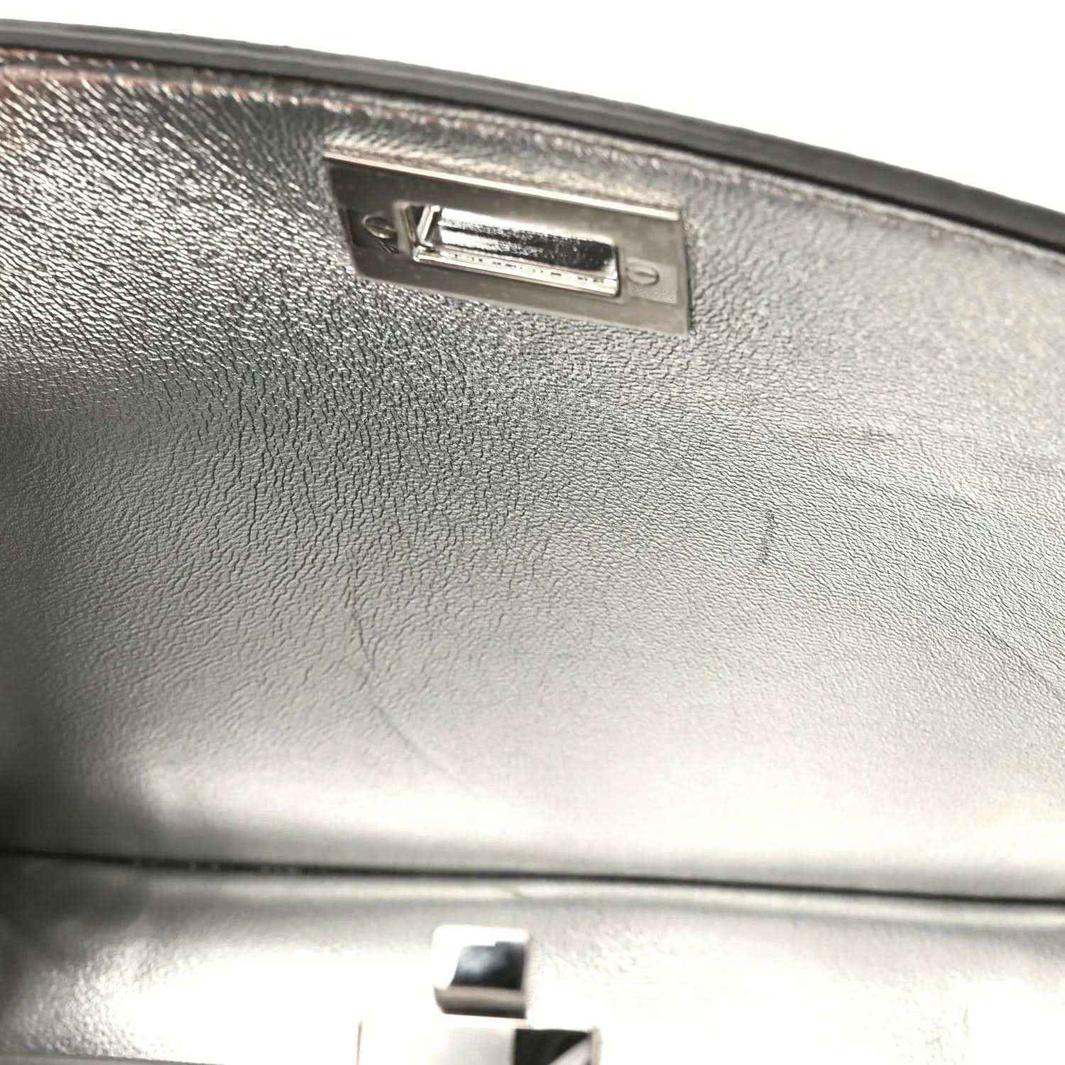 Silver satchel front with rectangular metal clasp and textured leather panel