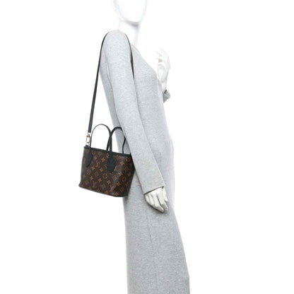 Reversible monogram shoulder bag worn by a model; long strap and gray exterior