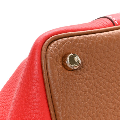 Brown leather corner with round metal snap and red edging, close-up