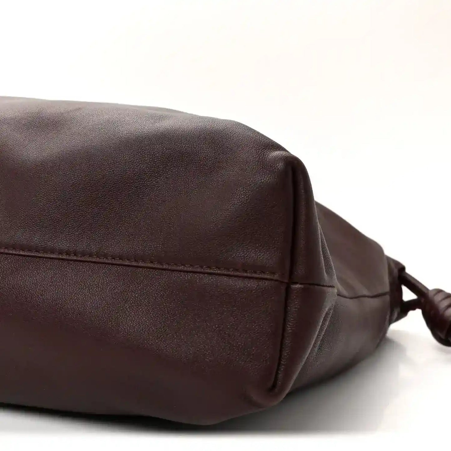 Dark burgundy leather clutch side panel with stitched flap edge