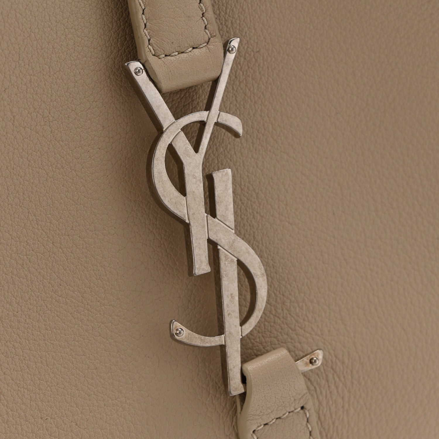 YSL metal logo and hanging leather tag on sea-salt beige hobo bag