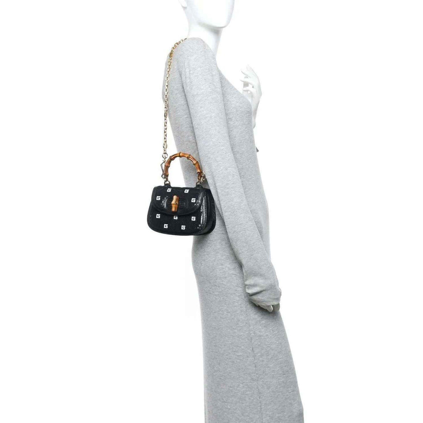 Gucci mini top handle bag, black embossed lizard texture, gold chain strap on model