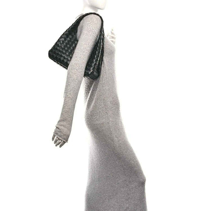 Black intrecciato leather shoulder bag with braided strap on a hanging hand