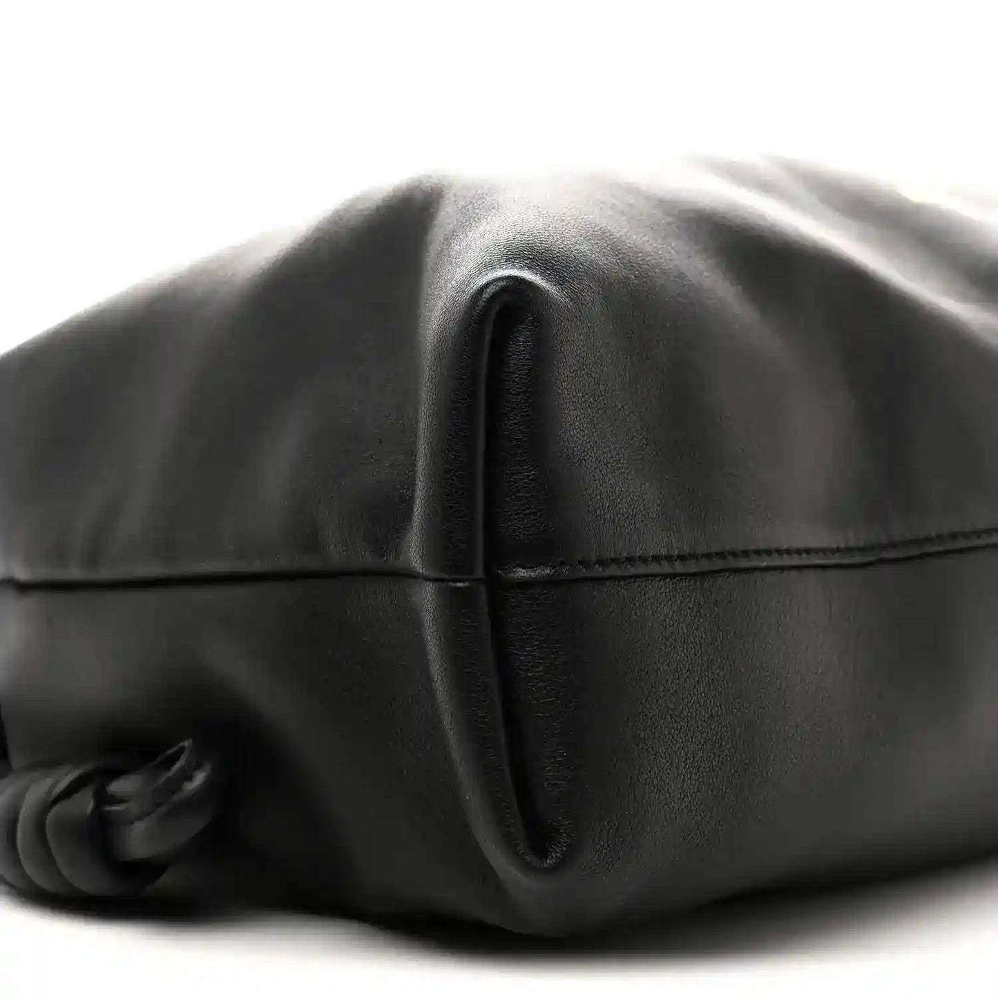 Black leather bag close-up of front seam and folded flap edge