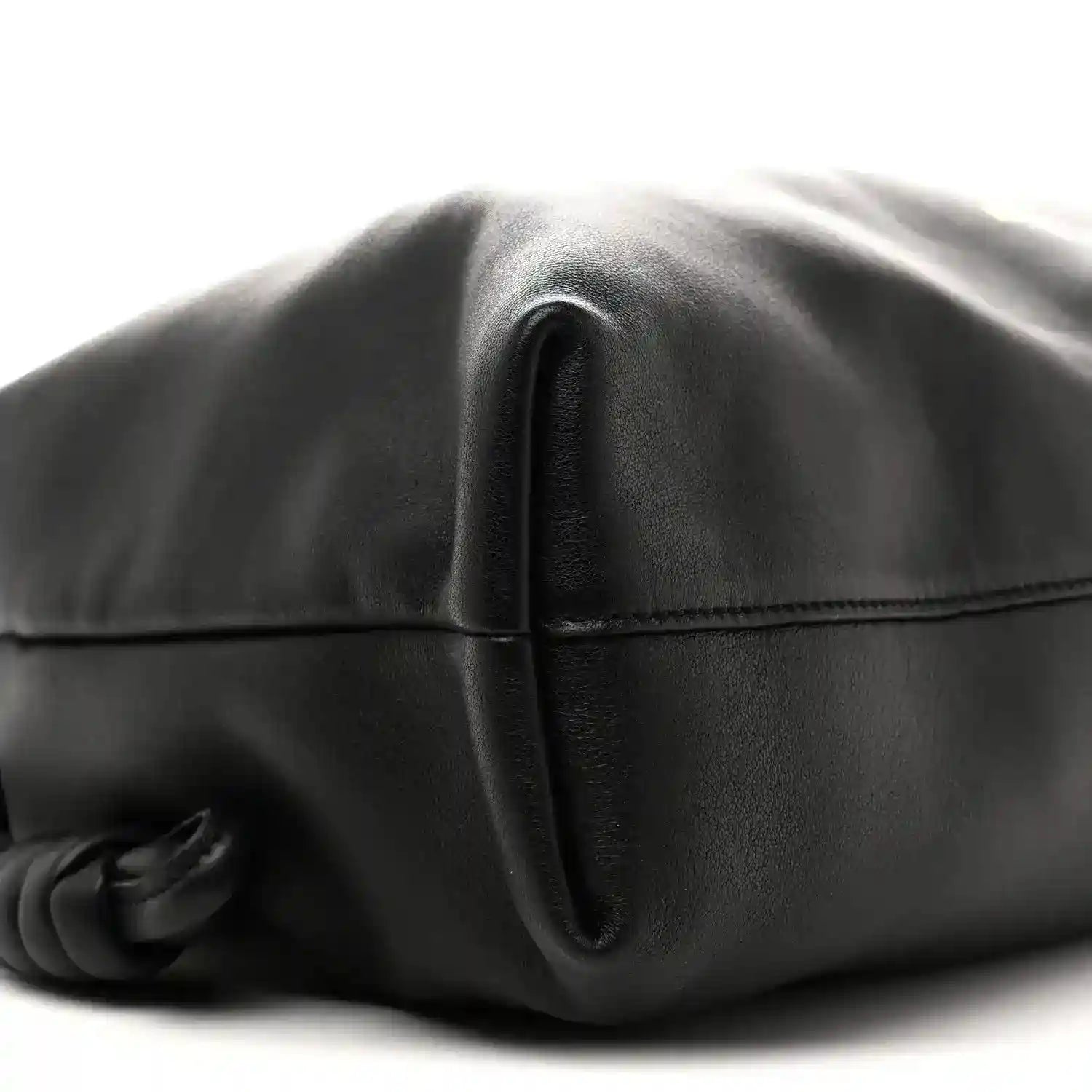 Black leather bag close-up of front seam and folded flap edge