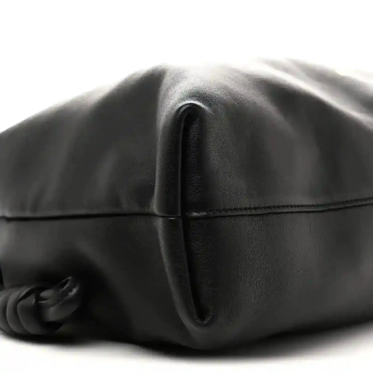 Black leather bag close-up of front seam and folded flap edge