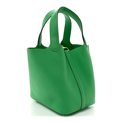 Green leather tote bag with two top handles and center zipper seam