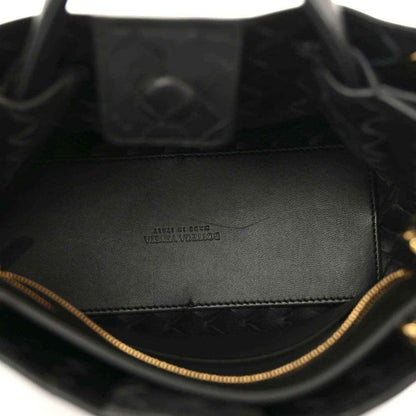 Black leather interior of chain shoulder bag with stitched lining and gold trim edge