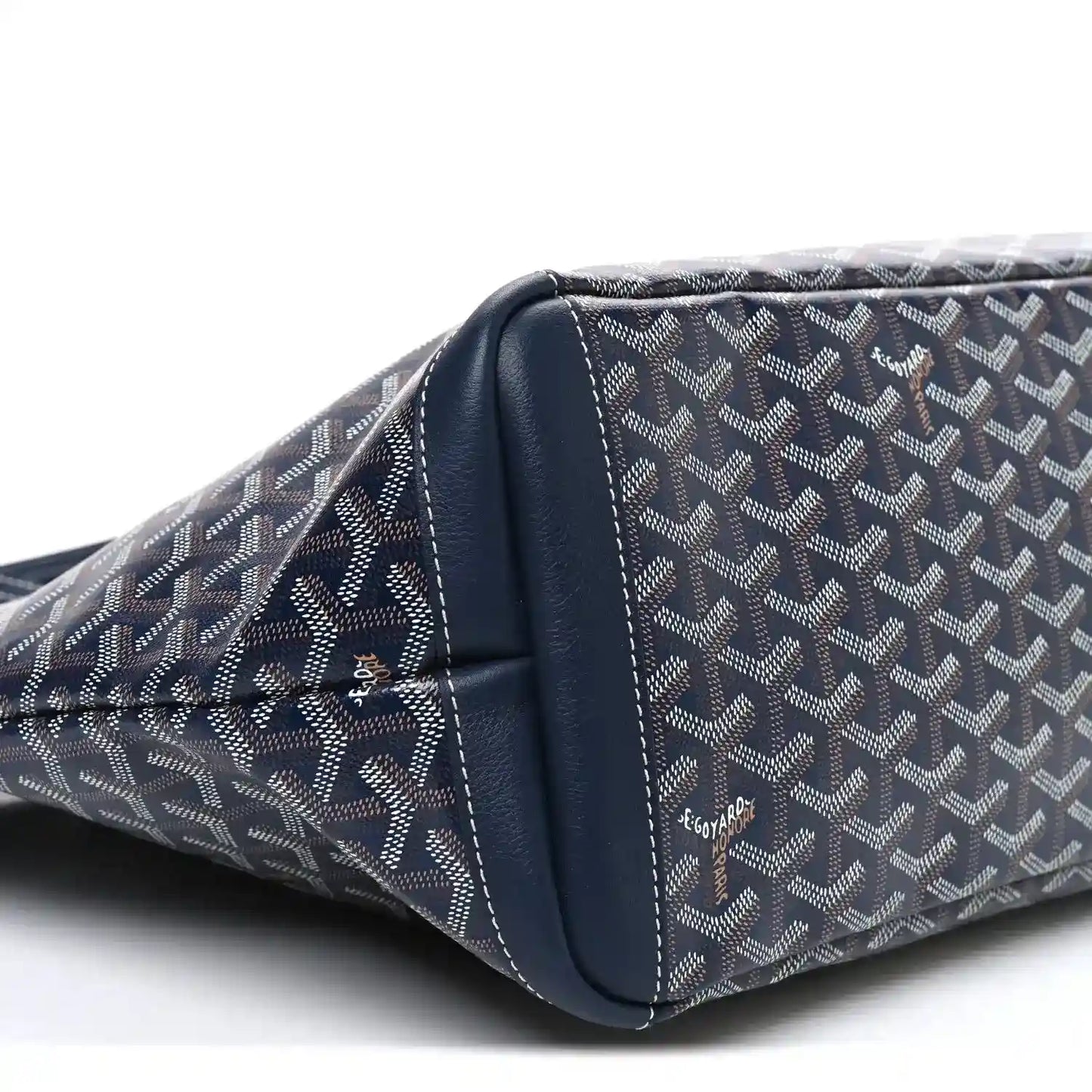 Navy tote bag side close-up with curved leather trim and stitched seams