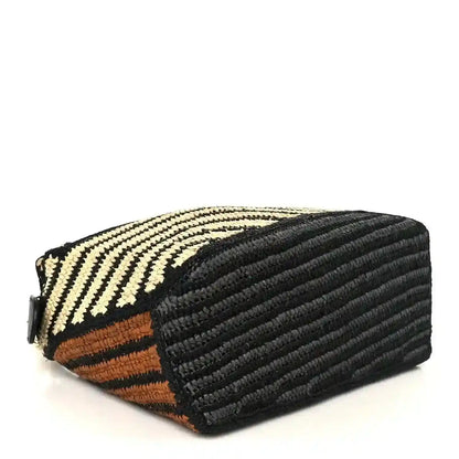 Small raffia puzzle bag side view with black textured leather panel and striped weave